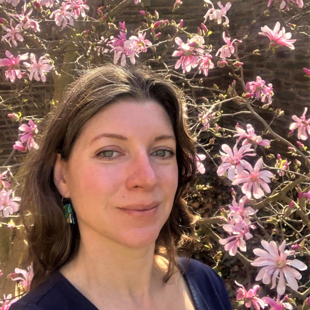 picture of Emily, standing outside, in front of flowering magnolia tree
