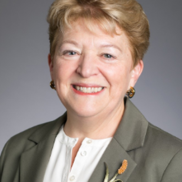 picture of Katherine, smiling, wearing a blouse and grey blazer