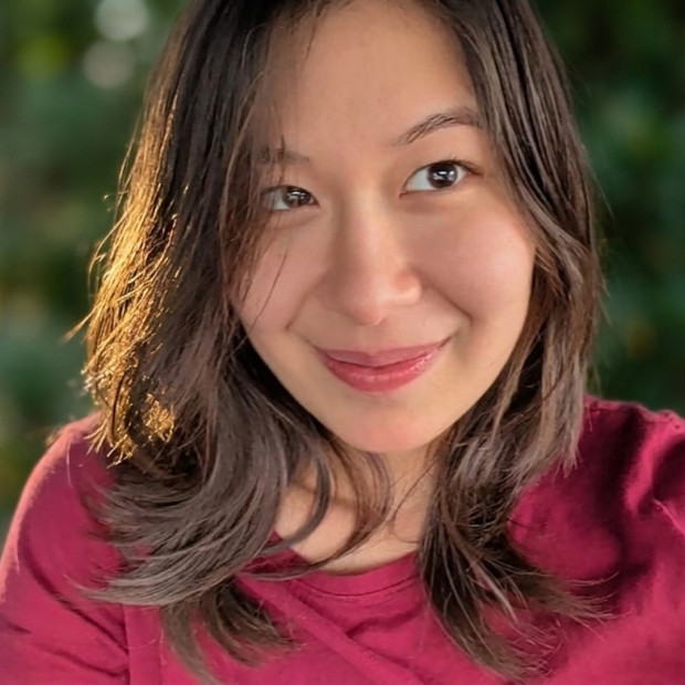 smiling, looking up to the right, green background, wearing red
