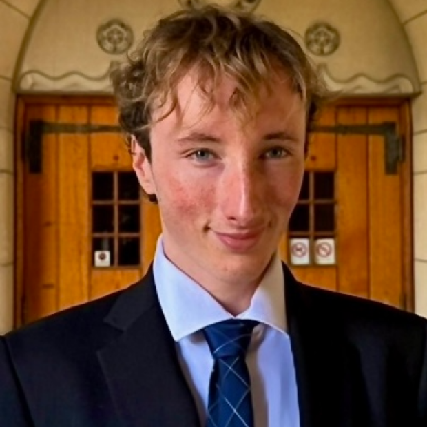 Ryan smiling in a suit and tie